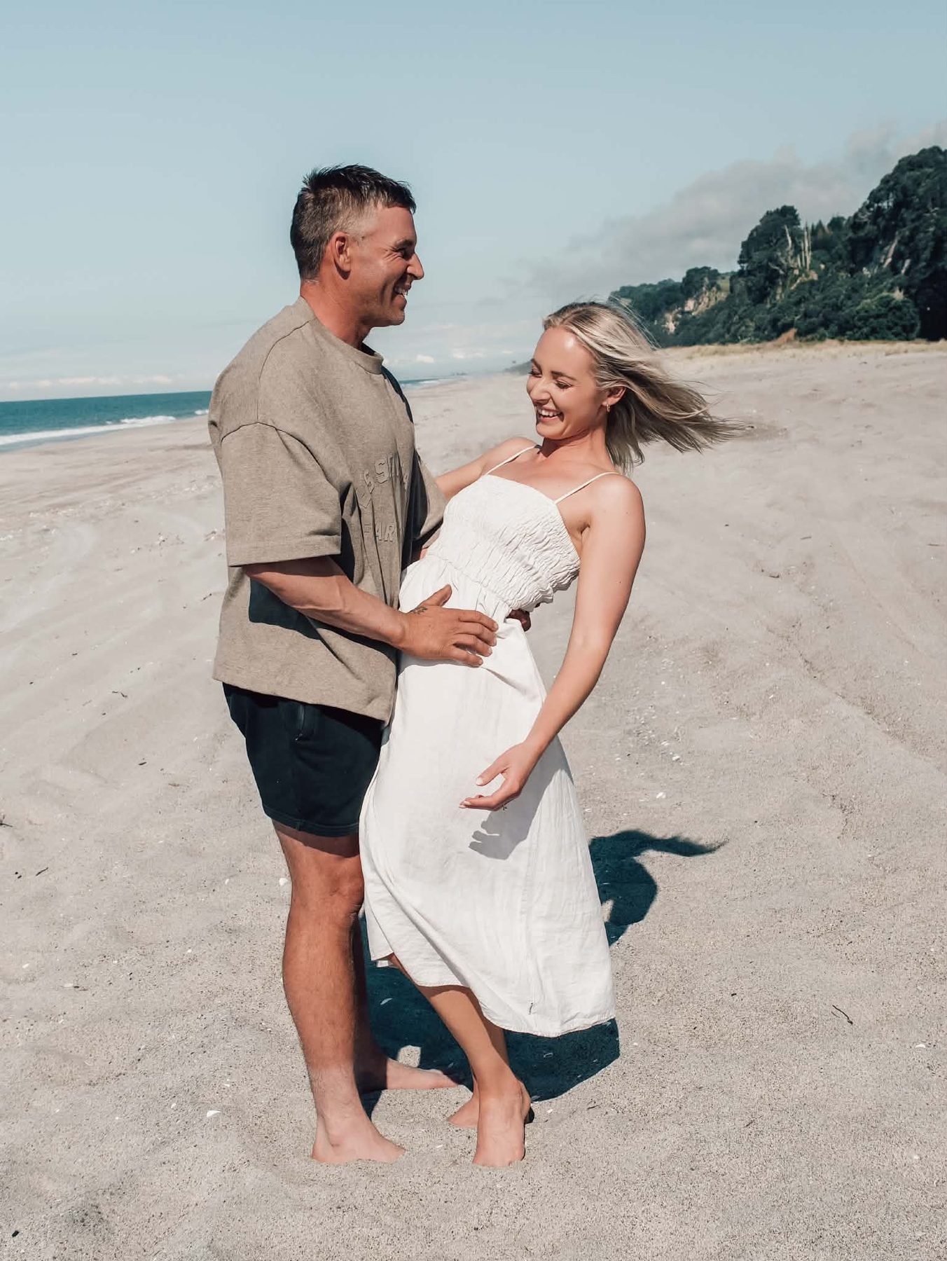 Lacy and Josh dancing and laughing together on the beach